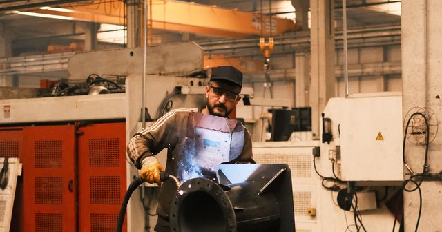 Metal parça üzerinde kaynakla çalışan imalat personeli